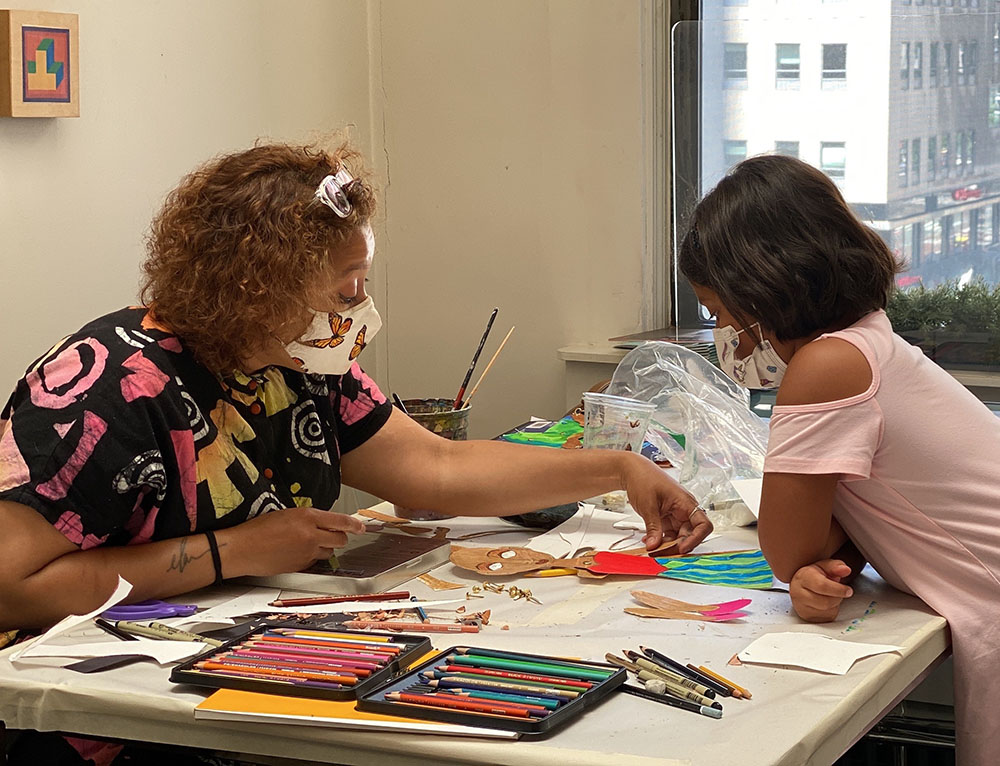 Teacher guiding student during beginner kids art classes activity in NYC studio